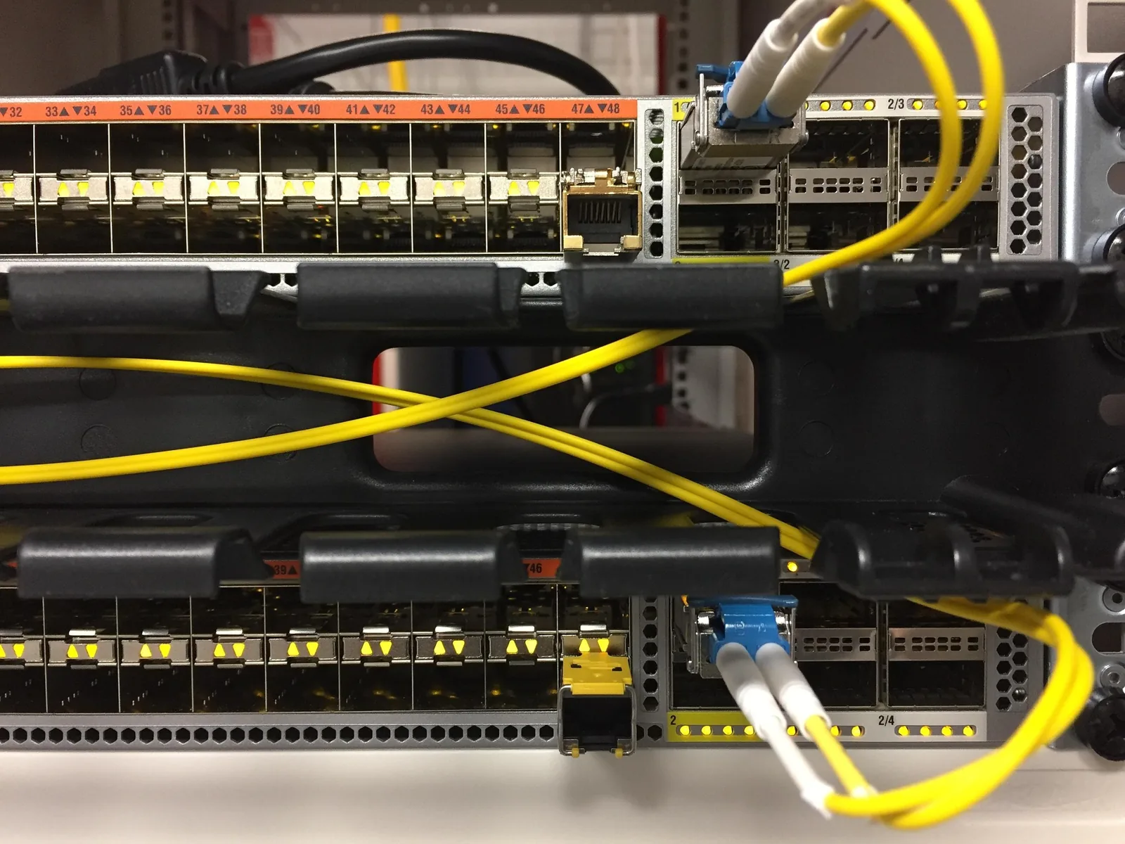 Switchs en baie avec modules fibre et câbles de service jaunes
